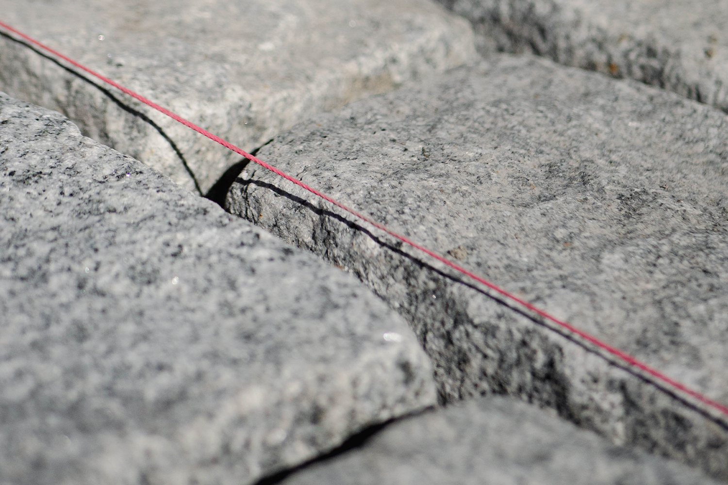 String line in place to align rows of cobblestone during a hardscape installation