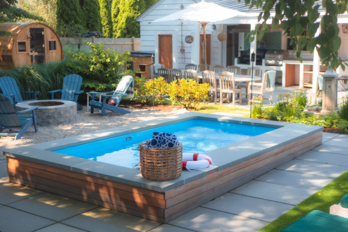 Small plunge pool in a well-maintained backyard with bluestone features.
