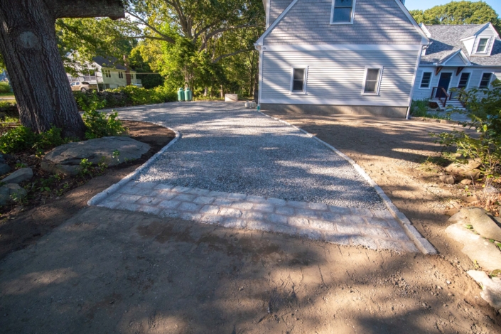 Cobblestone apron at the end of a crushed bluestone driveway with a cobblestone border.