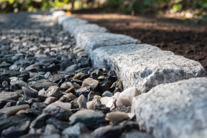 Close-up detail showing crushed bluestone driveway material framed by a cobblestone border.