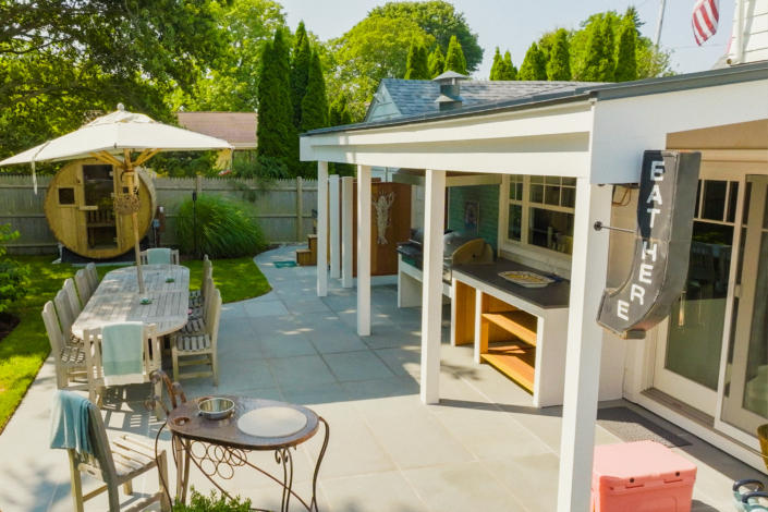 Backyard bluestone patio with a picnic table, an ice bath, a shower, and a sauna.
