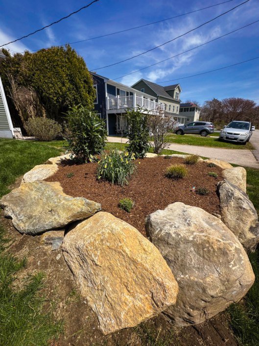 Ornamental garden in a raised bed lined with boulders.