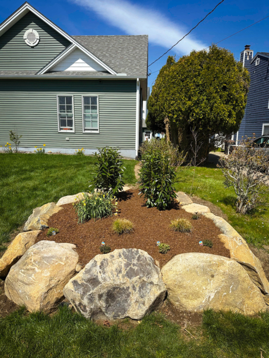 Ornamental garden in a raised bed lined with boulders.